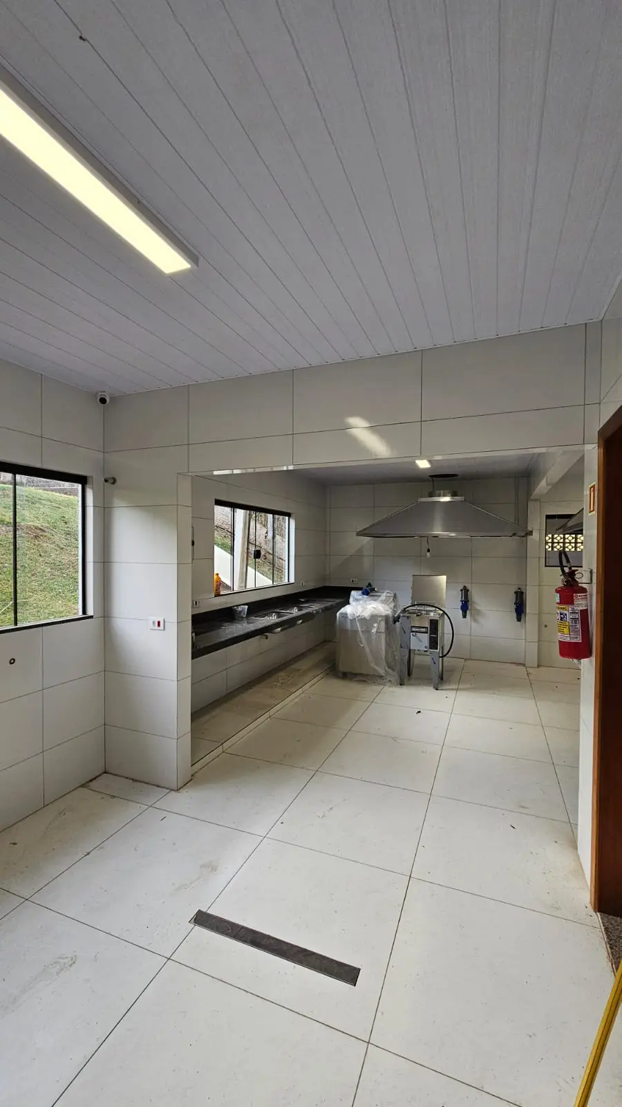 Cozinha industrial com coifa e equipamentos instalados